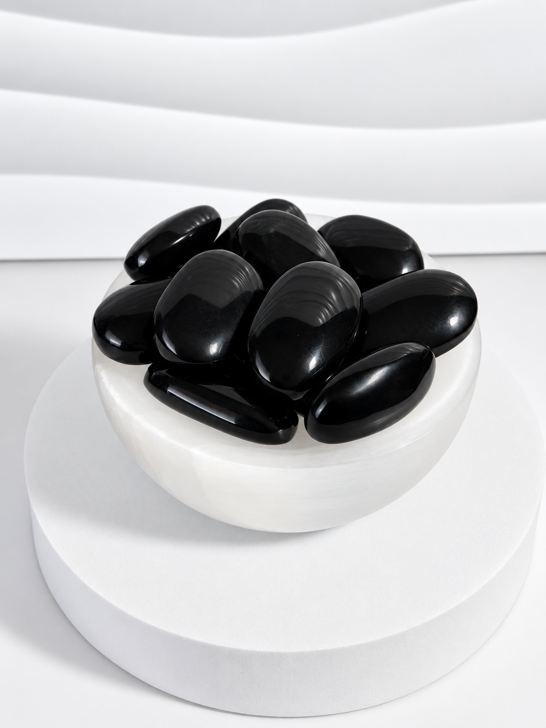 Black Obsidian 2-inch polished palm stones in white bowl