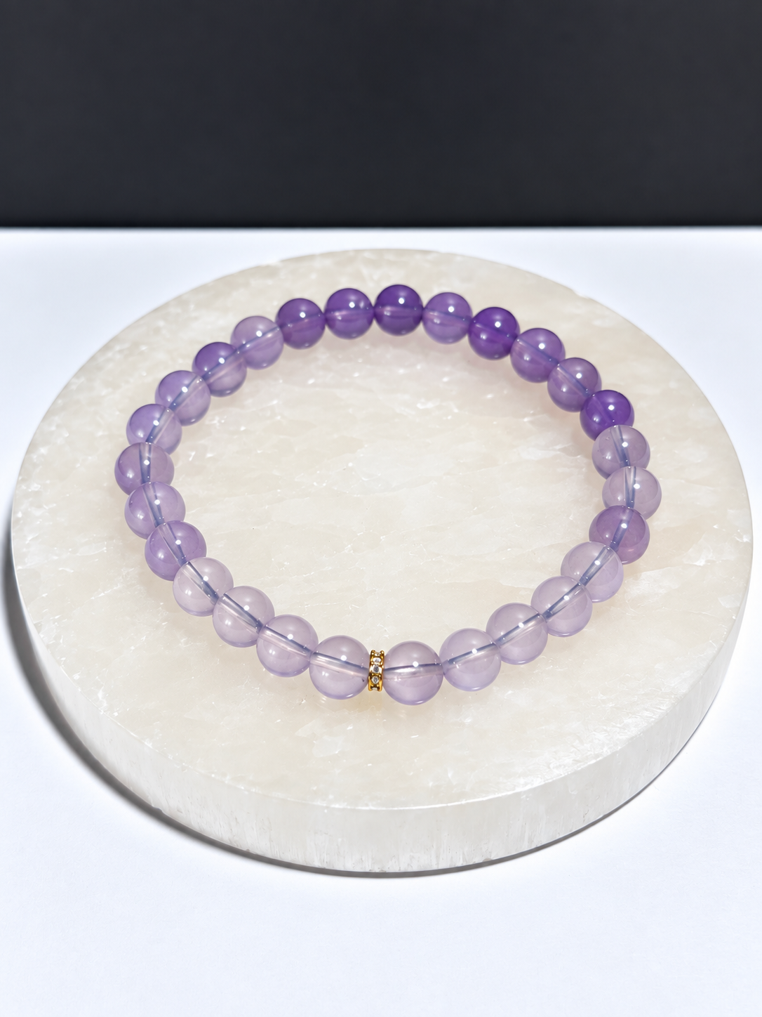Certified High-Quality Lavender Moon Quartz 5mm stretch bracelet on white stone display