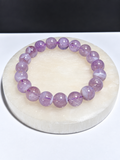 Certified Lavender Moon Quartz 10mm stretch bracelet on white stone display