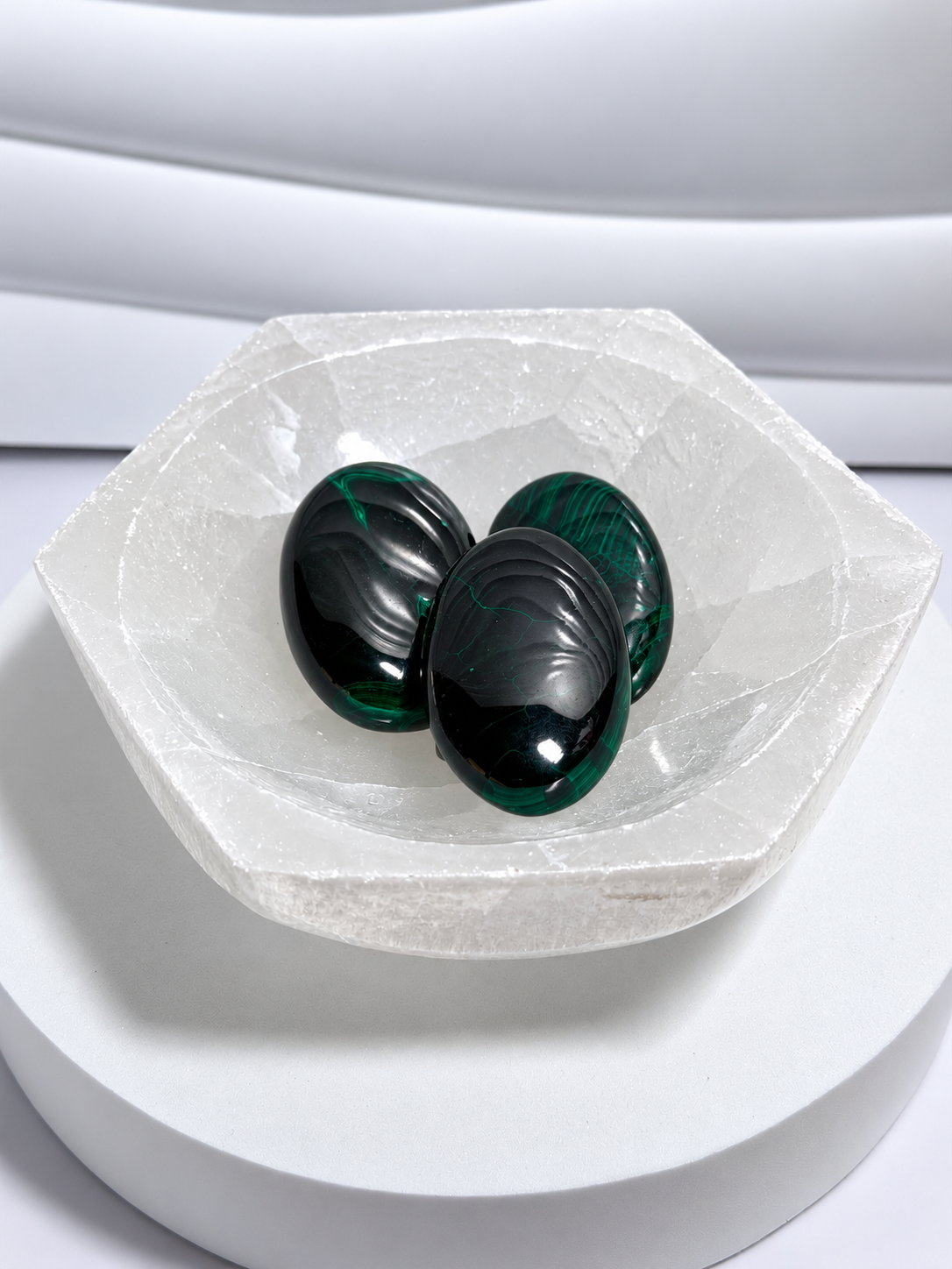 Three high-grade dark emerald green malachite palm stones approximately 2.5 inches long