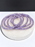 High-grade Lavender Moon Quartz 5mm round stretch bracelets on white stone display