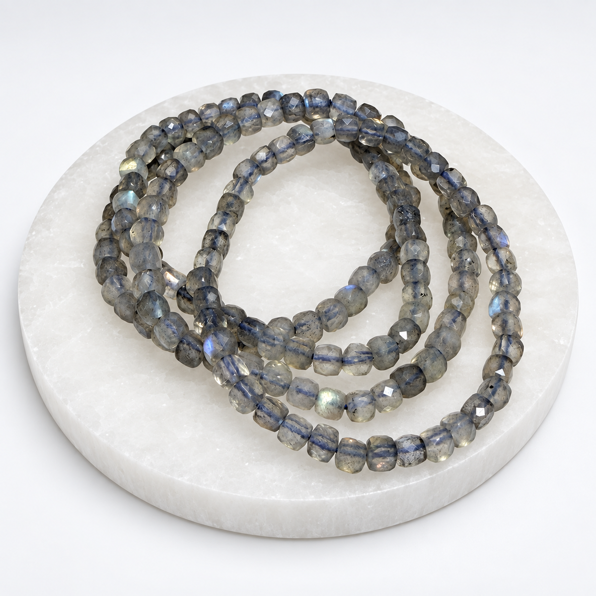 Labradorite 4mm faceted cube stretch bracelet on white stone display
