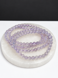 Lavender Moon Quartz 5mm round stretch bracelet on white stone display