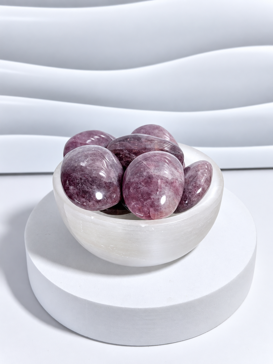 Lavender Rose Quartz palm stones in polished lavender-pink tones displayed in a white crystal bowl