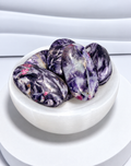 Mica with Pink Tourmaline palm stones in purple, lavender, gray and pink tones displayed in a white crystal bowl