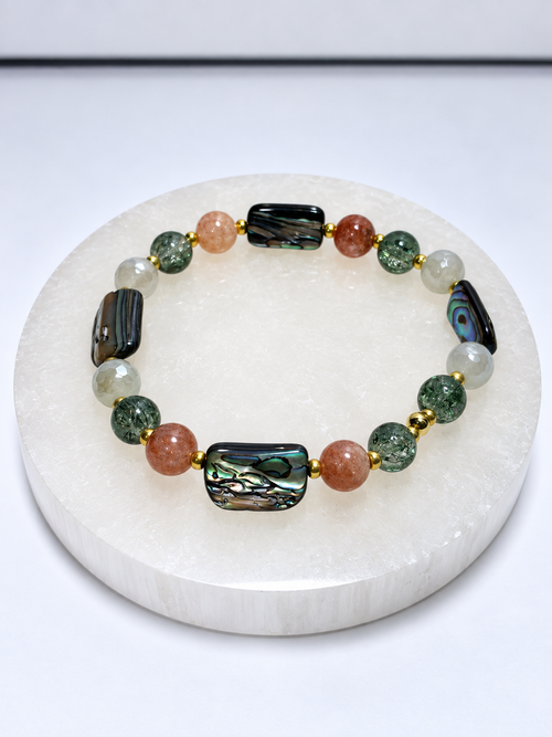 Size 7 stretch bracelet with four abalone beads, four sunstone beads, glass beads, and gold-toned spacers