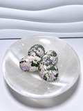 Peace Jade palm stones with green, cream, and lavender patterning displayed in a white crystal bowl