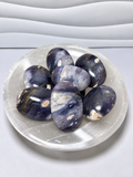 Purple chalcedony palm stones in polished blue-violet tones with natural cream and tan inclusions