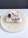 Purple scapolite crystal specimen in white matrix on pale stone display slab