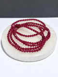 Ruby 3mm faceted stretch bracelet on white stone display