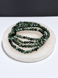 Seraphinite 4mm cube stretch bracelet on white stone display